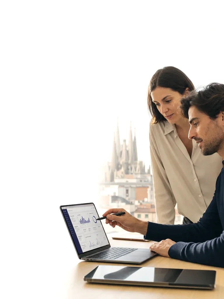 Dos profesionales usando un asistente de IA con Barcelona al fondo